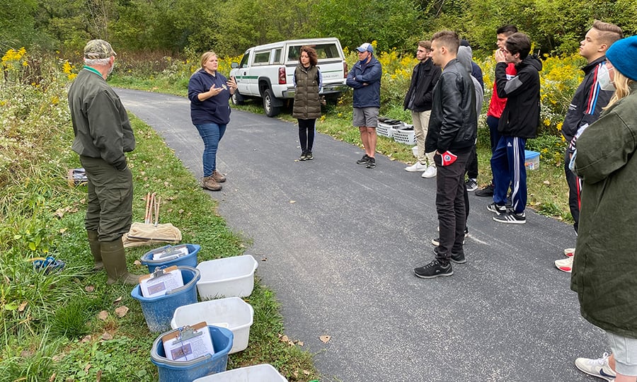 A district employee gives a quick lesson to the students during a visit to a forest preserve.