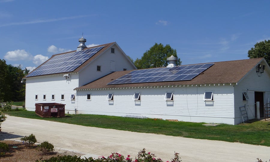 A white building with solar panels on the roof.