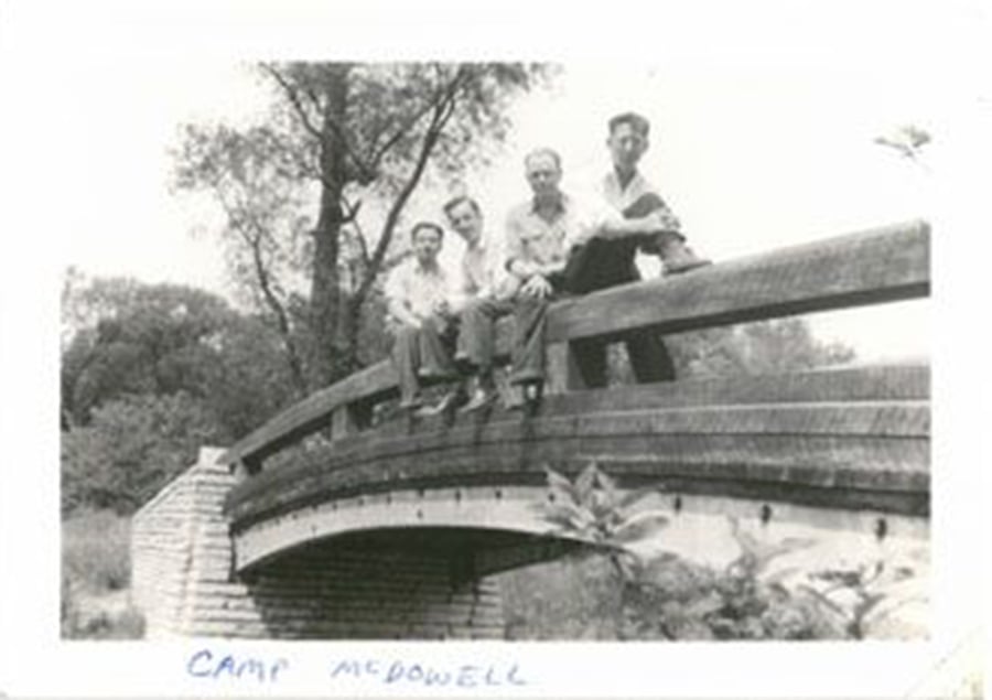 Four radar school trainees sit on a bridge in this photo from 1943.