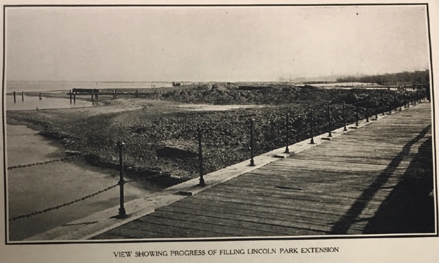 An old photograph of a bridge and shoreline with the caption, "View showing progress of filling Lincoln Park Extension."