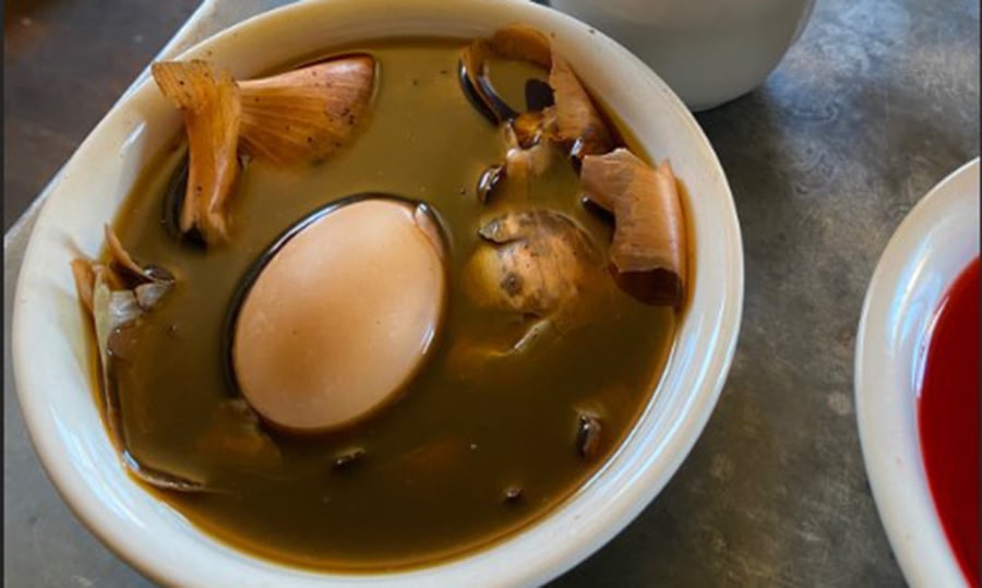Onion skins surround an egg in this small bowl to dye it brown.