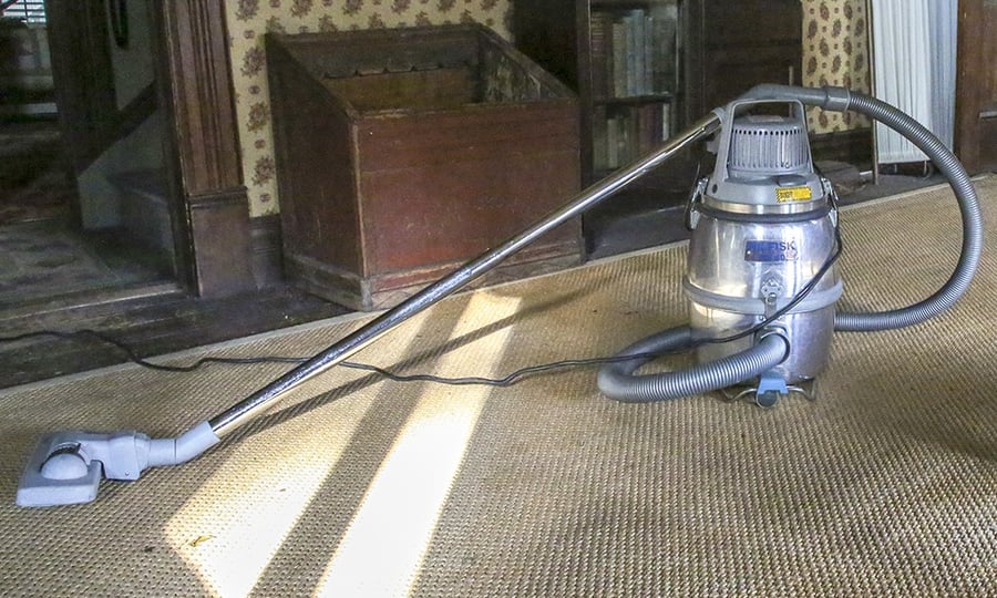 A vacuum made for museums rests on an old rug in the old farmhouse.