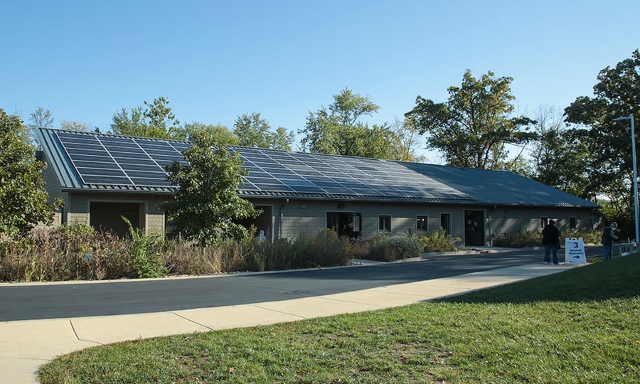 A single story, brick building with solar panels on the roof.