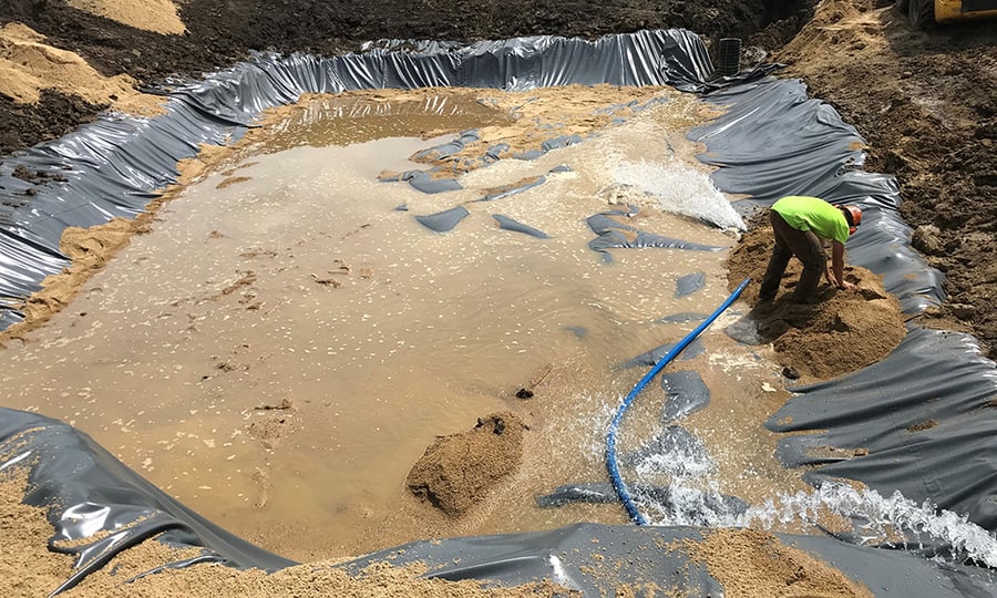 A liner is installed in the ditch to help filter the invasive mussels.