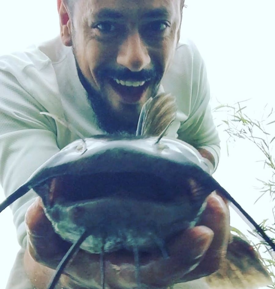 With a big smile, Jannotti holds a catfish up to the camera.