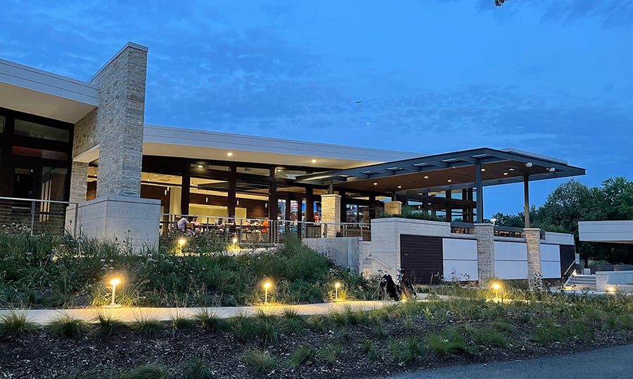 A view of the lighted clubhouse at dusk.