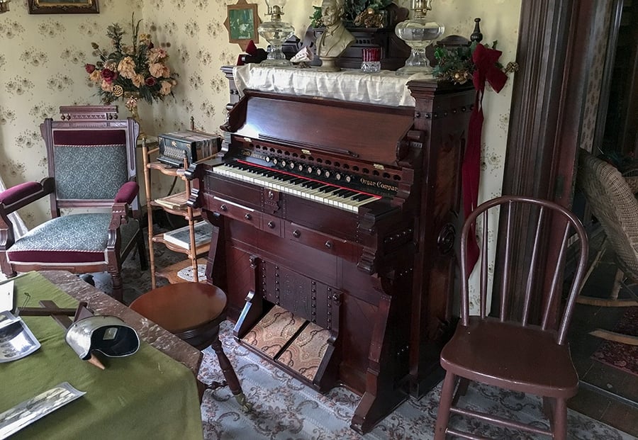 A bust and other items from the 1800s sit atop the restored organ.
