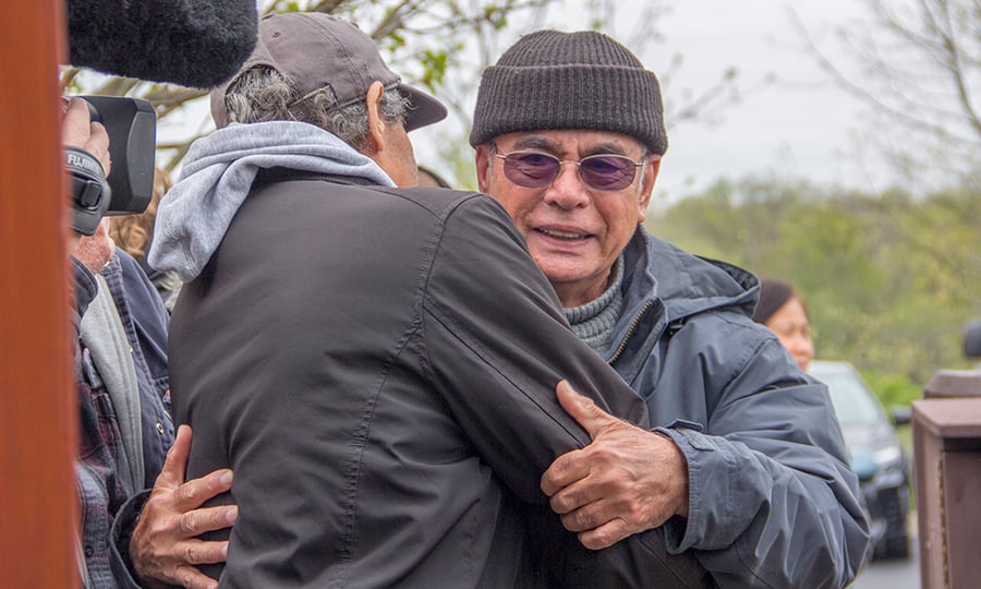 The man who was saved from drowning hugs one of his rescuers.