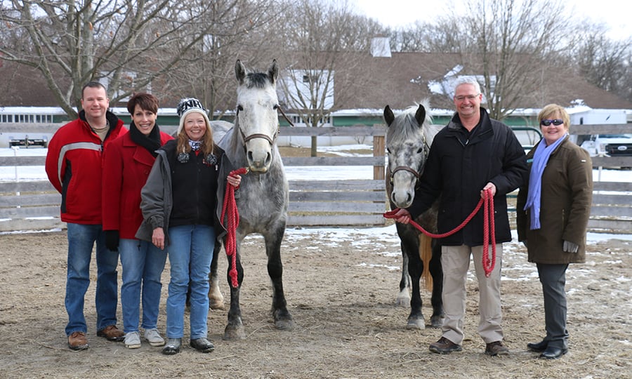 Five people stand with the two horses that were donated to Danada.