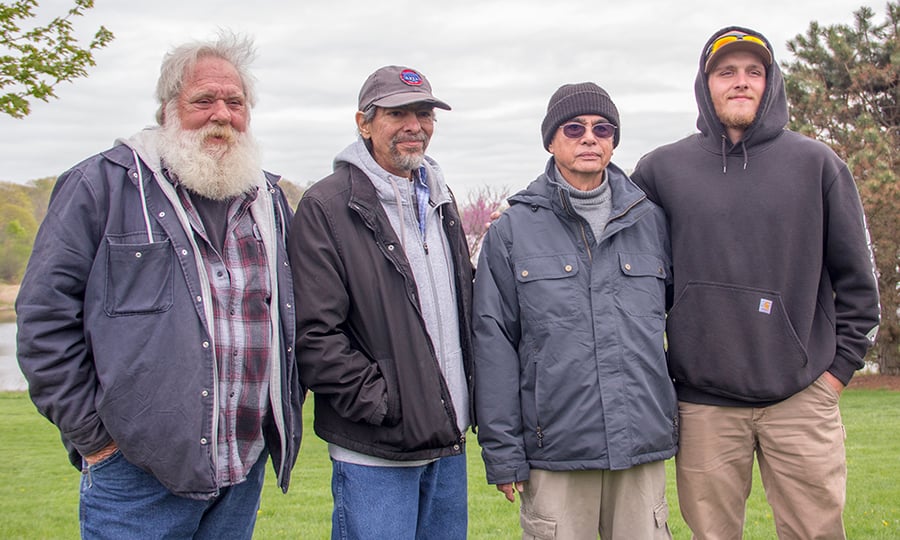 The man who nearly drowned poses for a photo with the men who helped rescue him.