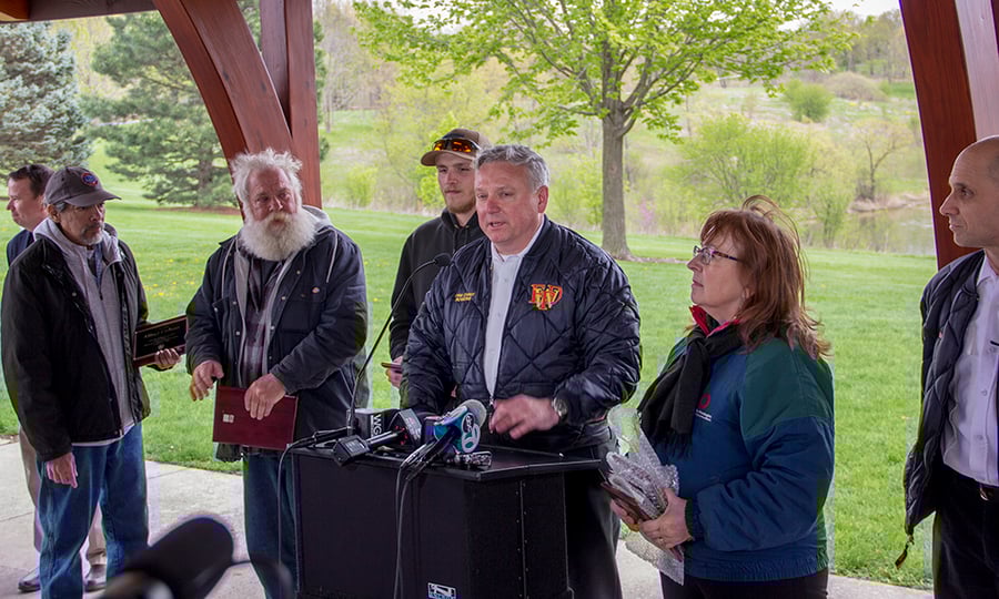Fire District officials at a prodium also present the rescuers with plaques.
