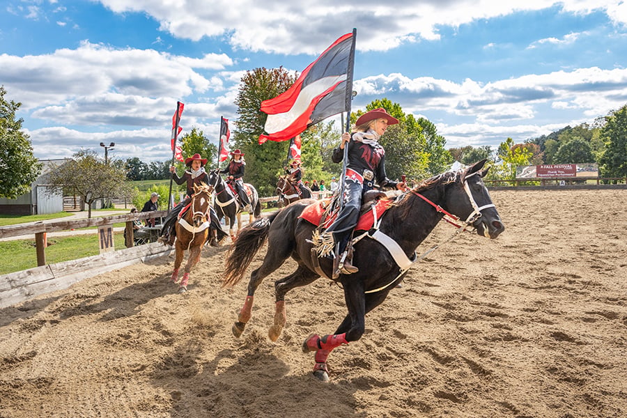 four performers on horseback at the Danada Equestrian Center outdoor arena