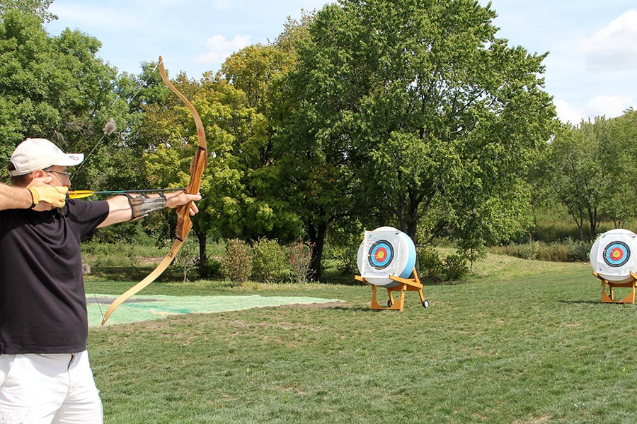 man shooting a bow and arrow at a target