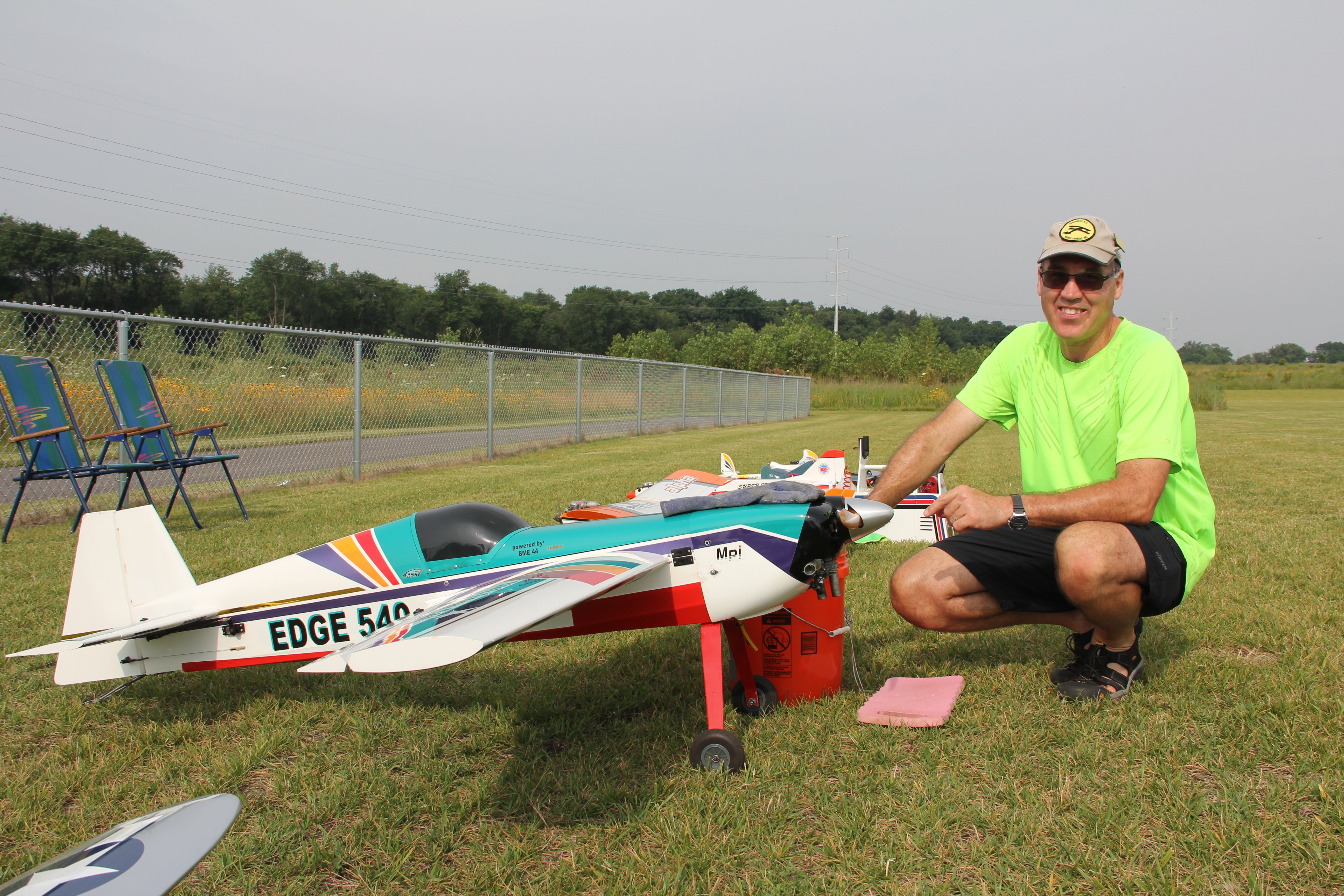 man posing next to model airplane