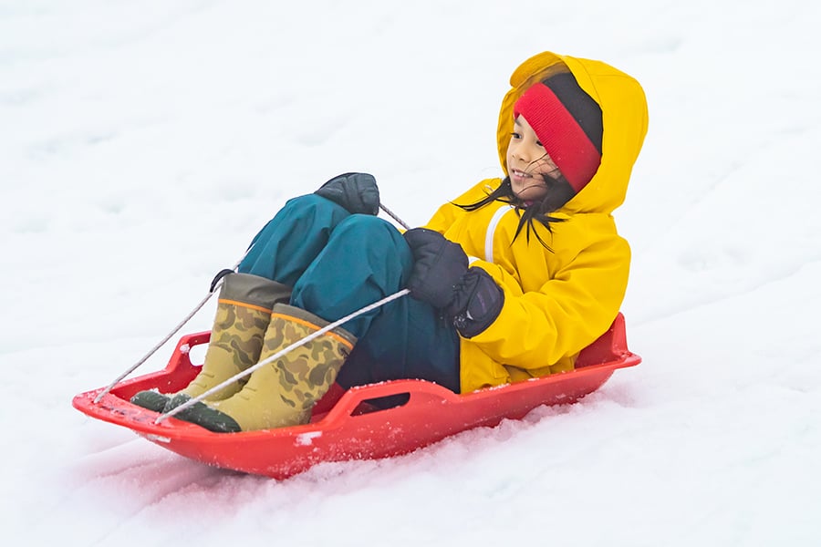 child sledding down a hill