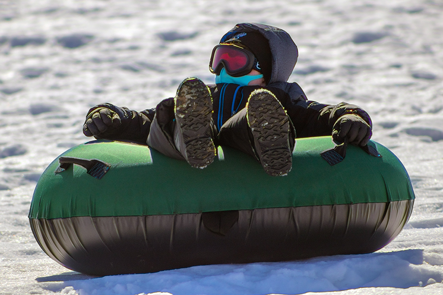 child on a tube sledding down a hill