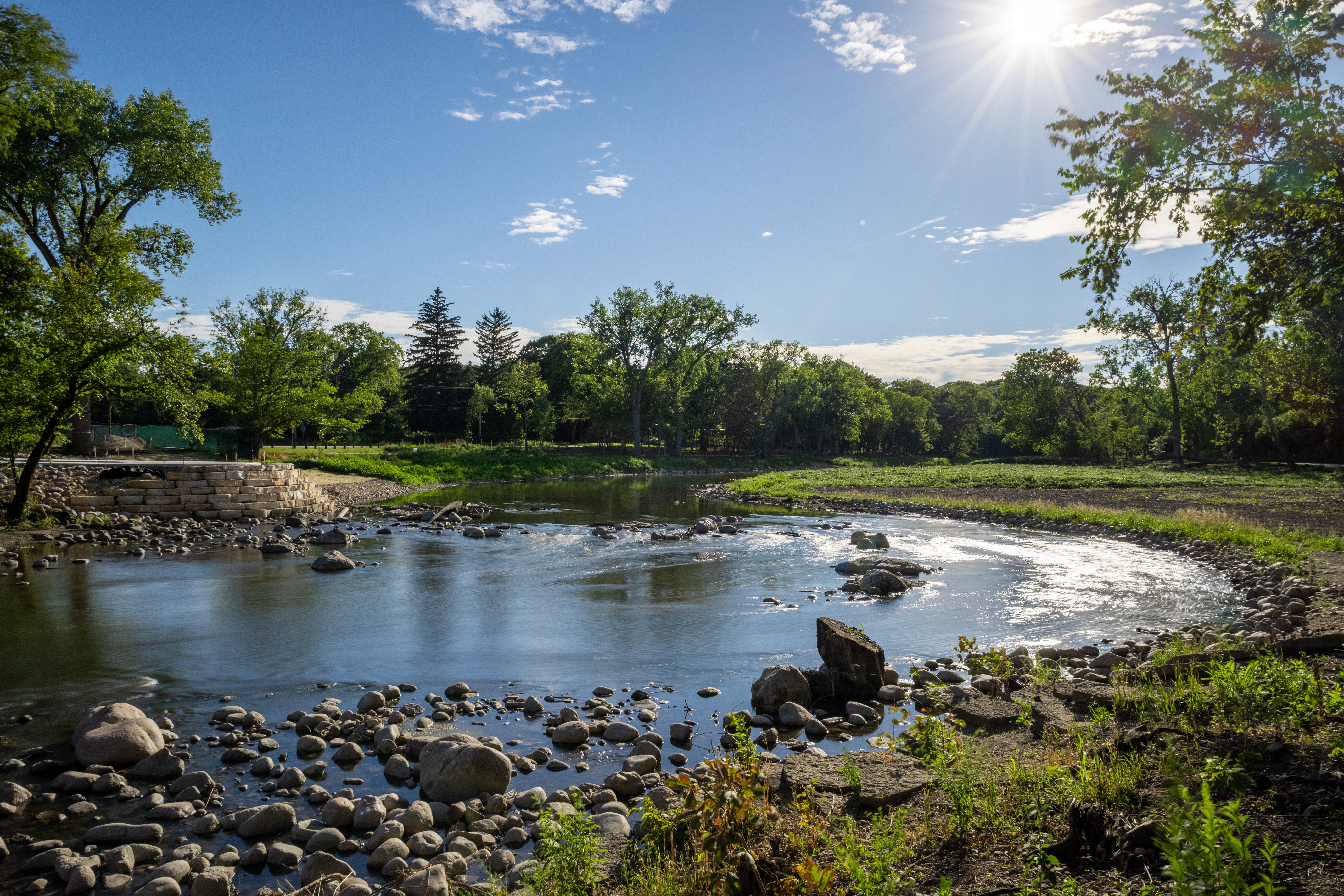 Boulders form riffles in a winding creek.