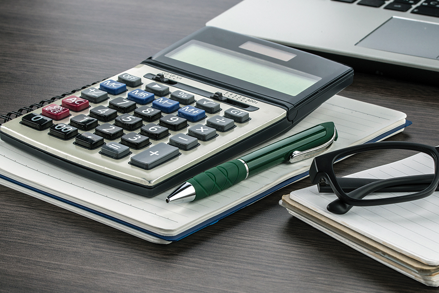 a calculator on a table next to a pen