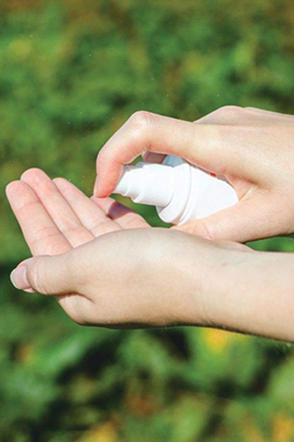 a woman putting sunscreen into the palm of her hand