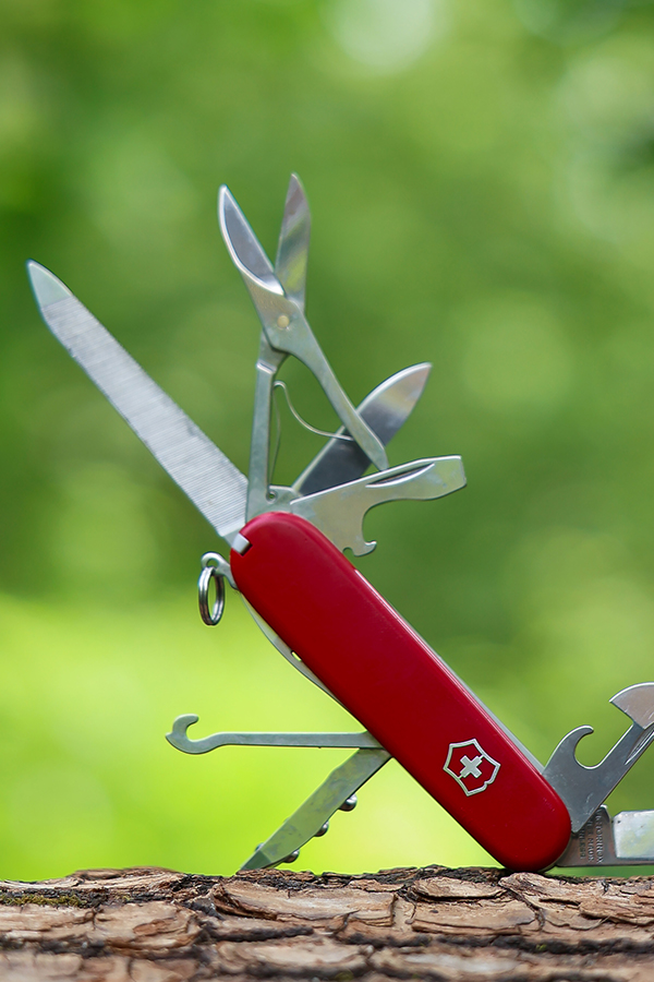 a small multitool showing a knife, clippers, and a saw