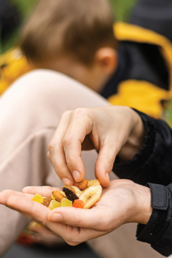 person eating trail mix of nuts and dried fruits