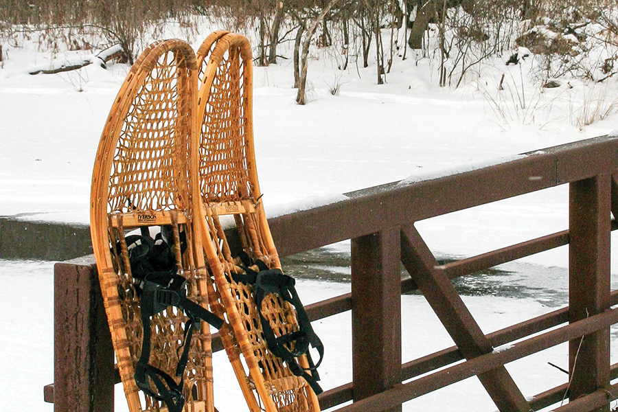 a pair of Athabaskan or Alaskan snowshoes propped up against a fence