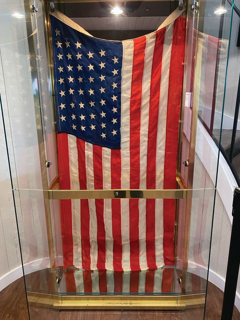 An American flag with 46 stars hands in a case.