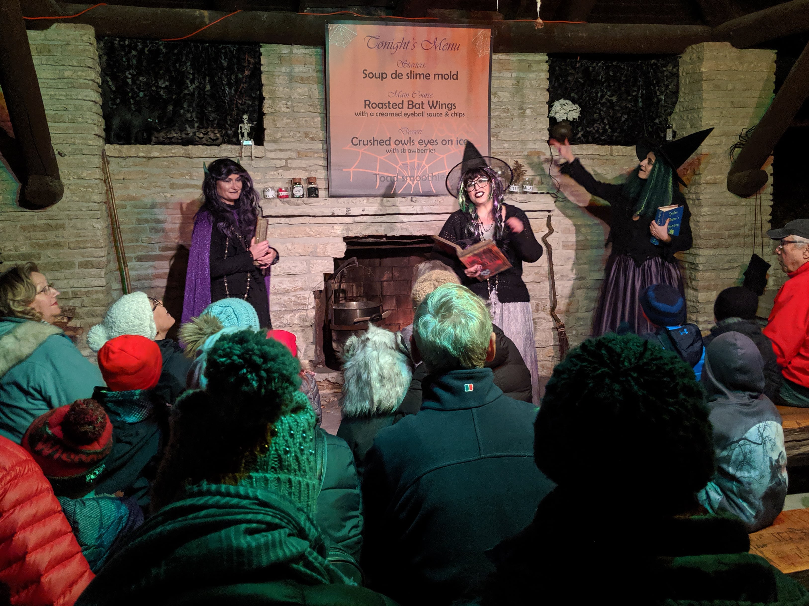 Costumed employees share a Halloween tale with an audience of all ages.