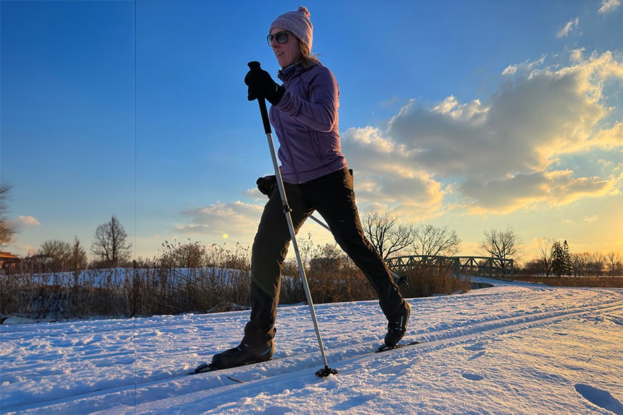 a woman cross-country skiing on a groomed trail a woman cross-country skiing on a groomed trail